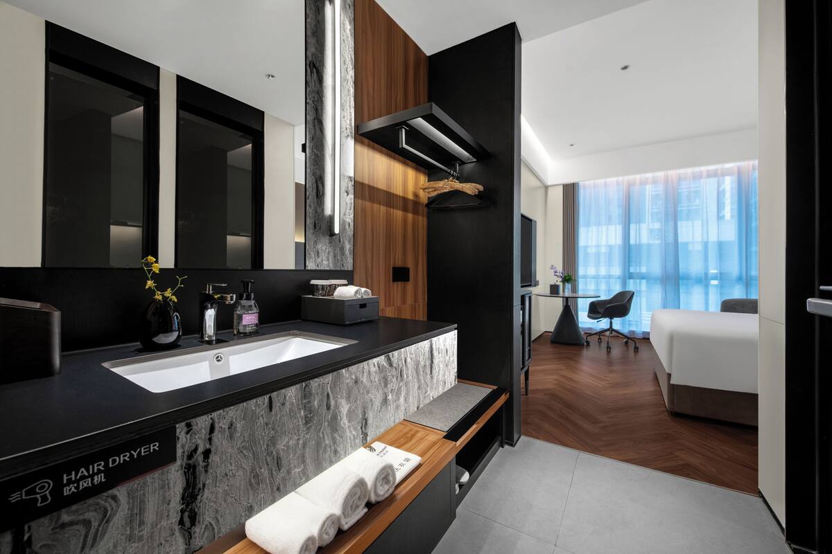 A modern bathroom with a hair dryer, a sink, and a mirror.