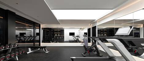 A modern gym with treadmills, dumbbells, and exercise equipment.