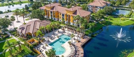 A resort with a central pool, a circular deck, and a view of the surrounding area.