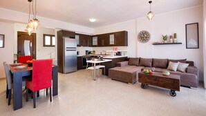 Un salon moderne comprenant un coin repas, une kitchenette et un ensemble de canapés.