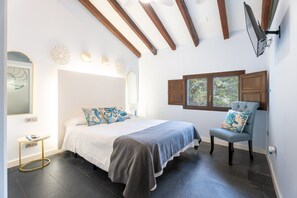 A bedroom with a bed, bedside table, chair, and window. - Room 'Mar' with Mountain View, Wi-Fi and Air Conditioning (Navajas)