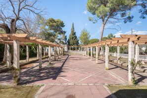 A covered walkway with columns and a tiled floor, surrounded by trees. - Room 'Sol' with Mountain View, Wi-Fi and Air Conditioning (Navajas)