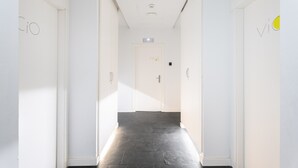A corridor with white walls, a dark floor, and doors with 'CIO' and 'VIO' signs. - Room 'Rocío' with Mountain View, Wi-Fi and Air Conditioning (Navajas)