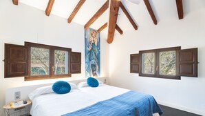A bedroom with a large bed, wooden beams, a painting, and windows with shutters. - Room 'Rocío' with Mountain View, Wi-Fi and Air Conditioning (Navajas)