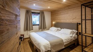 Una stanza con pannelli di legno, un letto, una finestra con tende e una testiera.