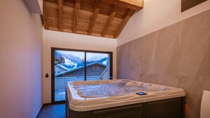 A hot tub in a room with a wooden ceiling and a view of a snowy mountain. - Chalet '-Spa Le Cervin' with Mountain View, Private Terrace and Wi-Fi (Valloire)
