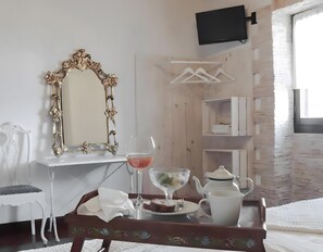 A room with a white desk, a mirror with an ornate frame, a tray with a teapot, a glass, and a plate with food. - Holiday Home with Mountain Views, Private Garden and Wi-Fi (Deba)