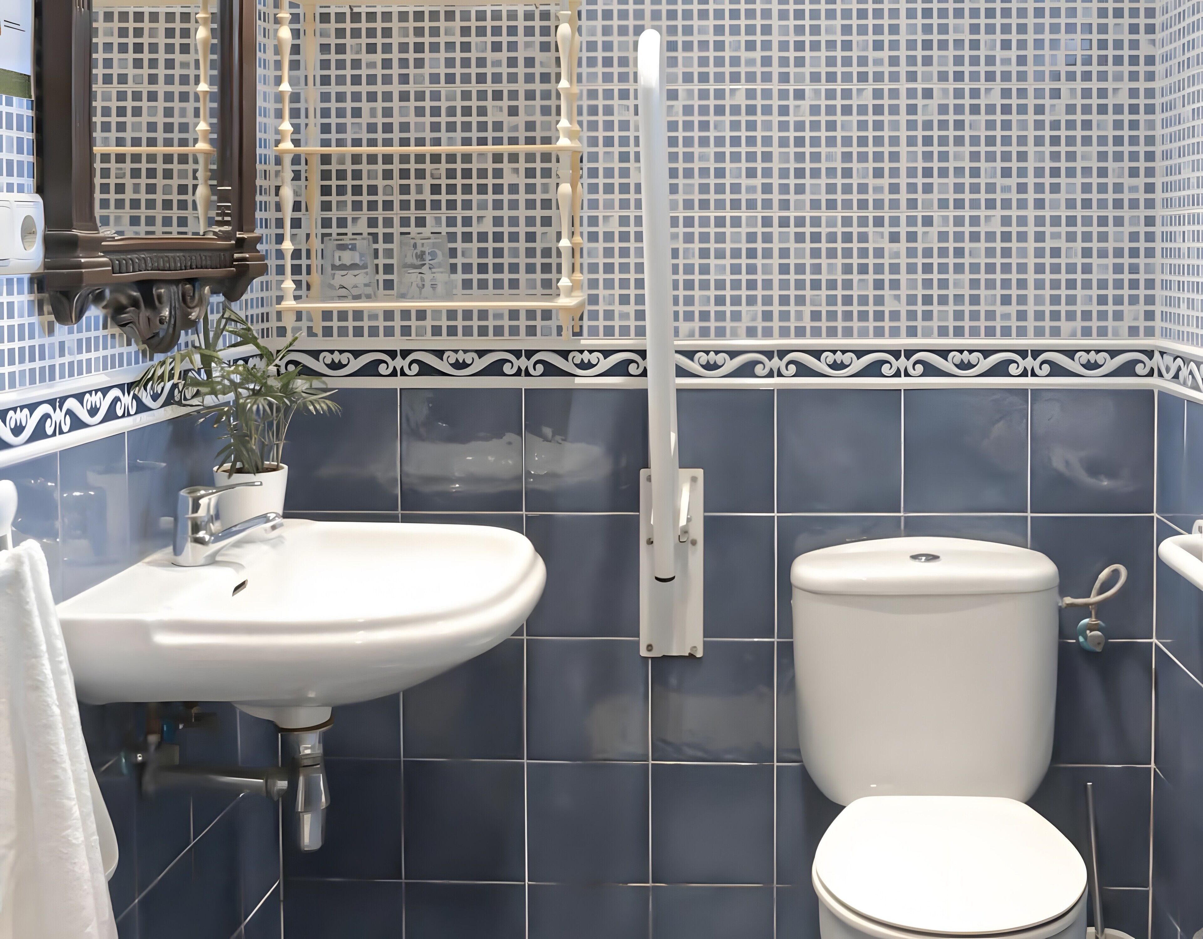 Un baño con lavamanos blanco, inodoro y espejo.