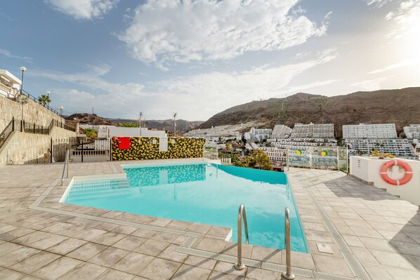 A rooftop pool with a clear view of the surrounding buildings and hills.