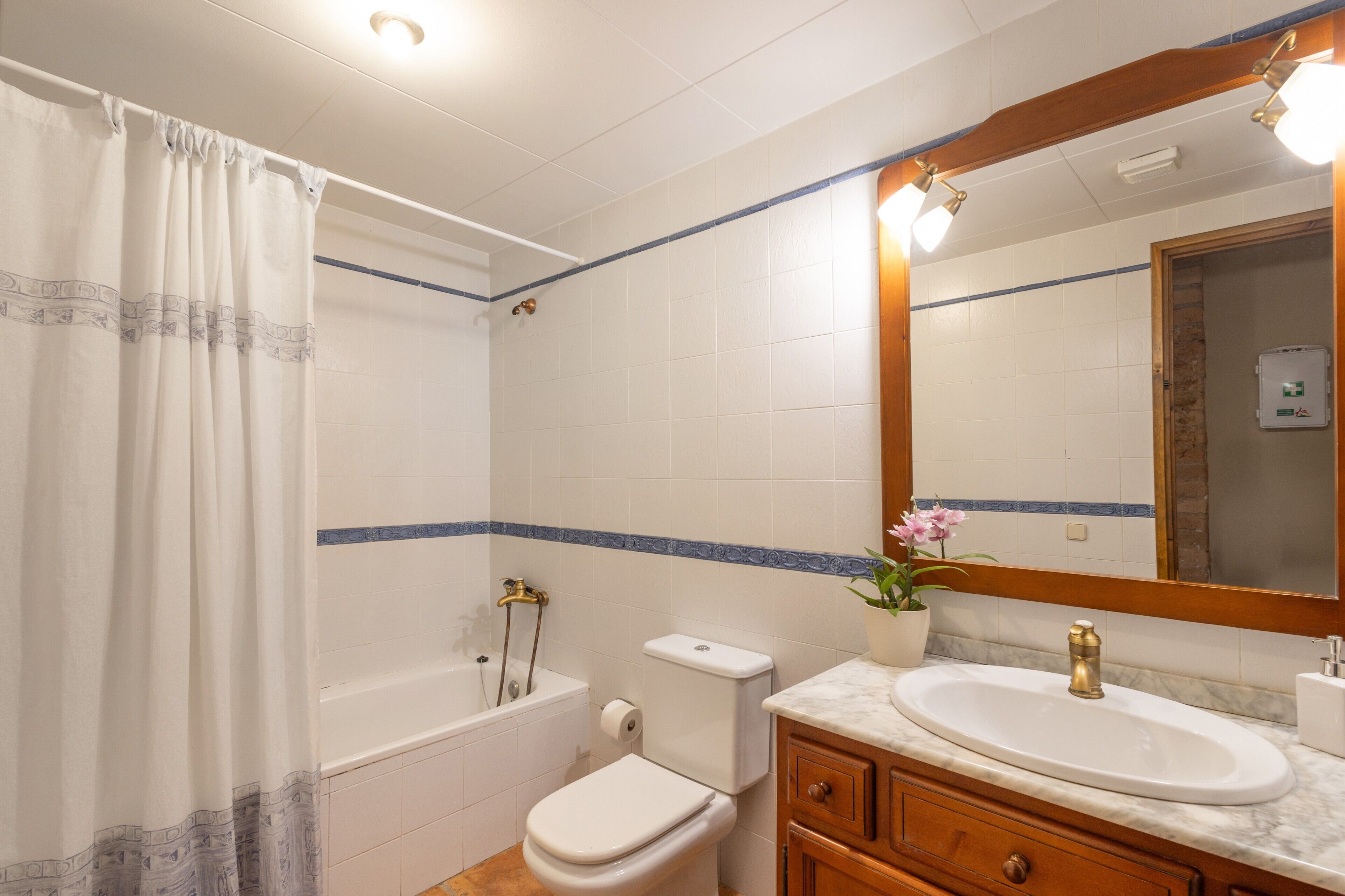 Un baño con bañera, inodoro, lavabo y espejo.