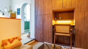 A wooden cabinet with a shelf, a chair, and a potted plant. - Cozy renovated studio in central Biarritz - 2 min to beaches & market - Absolute calm (Biarritz)