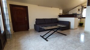 A living room with a sofa, a coffee table, and a door.