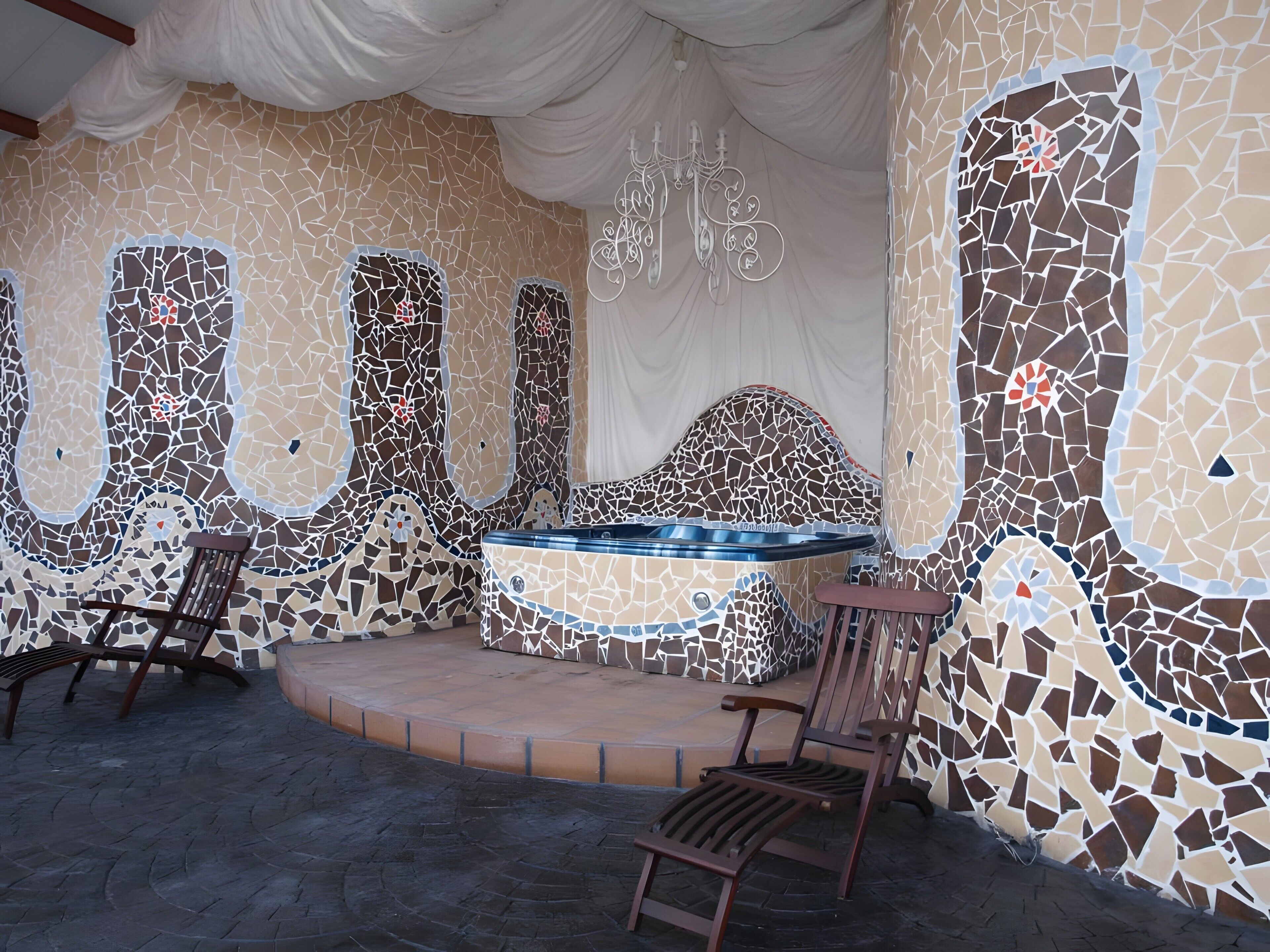 Un espace spa avec des murs décorés de mosaïques, un jacuzzi et des sièges.