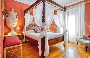 A four-poster canopy bed with white drapes, a large vase on a bedside table, and a red upholstered bench. - Suite 2 with Mountain Views, Shared Terrace and Wi-Fi (CIDONES)