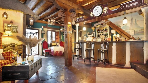 A rustic interior with a stone floor, wooden beams, a bar area, and a clock. - Suite 5 with Mountain Views, Shared Terrace, and Wi-Fi (CIDONES)