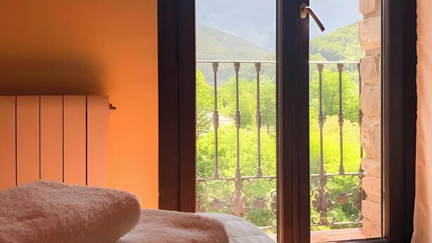 A bedroom with a bed, a window with a view of a balcony and mountains. - Apartment 'Yerga' with Wi-Fi (Tella)