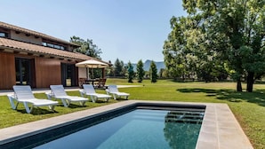 A swimming pool with lounge chairs and a patio area.