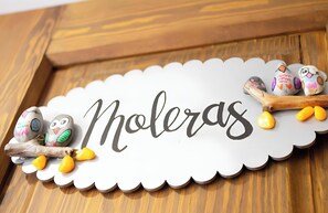 A wooden table with a white decorative sign that reads 'Moleras' and decorated eggs.