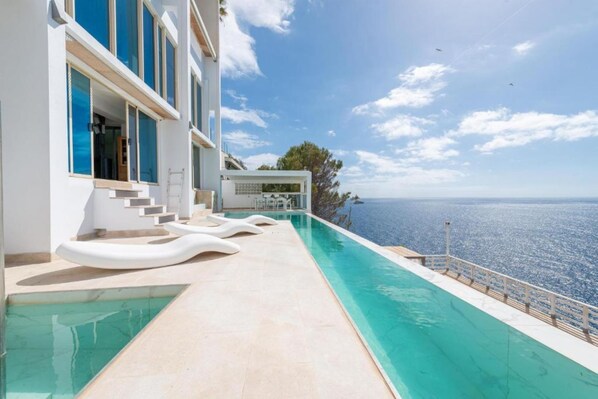 A modern building with a pool overlooking the sea.