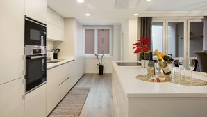 Una cocina moderna con electrodomésticos integrados, una isla central y un comedor con vistas.