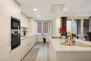 Una cocina moderna con electrodomésticos integrados, una isla central y un comedor con vistas.