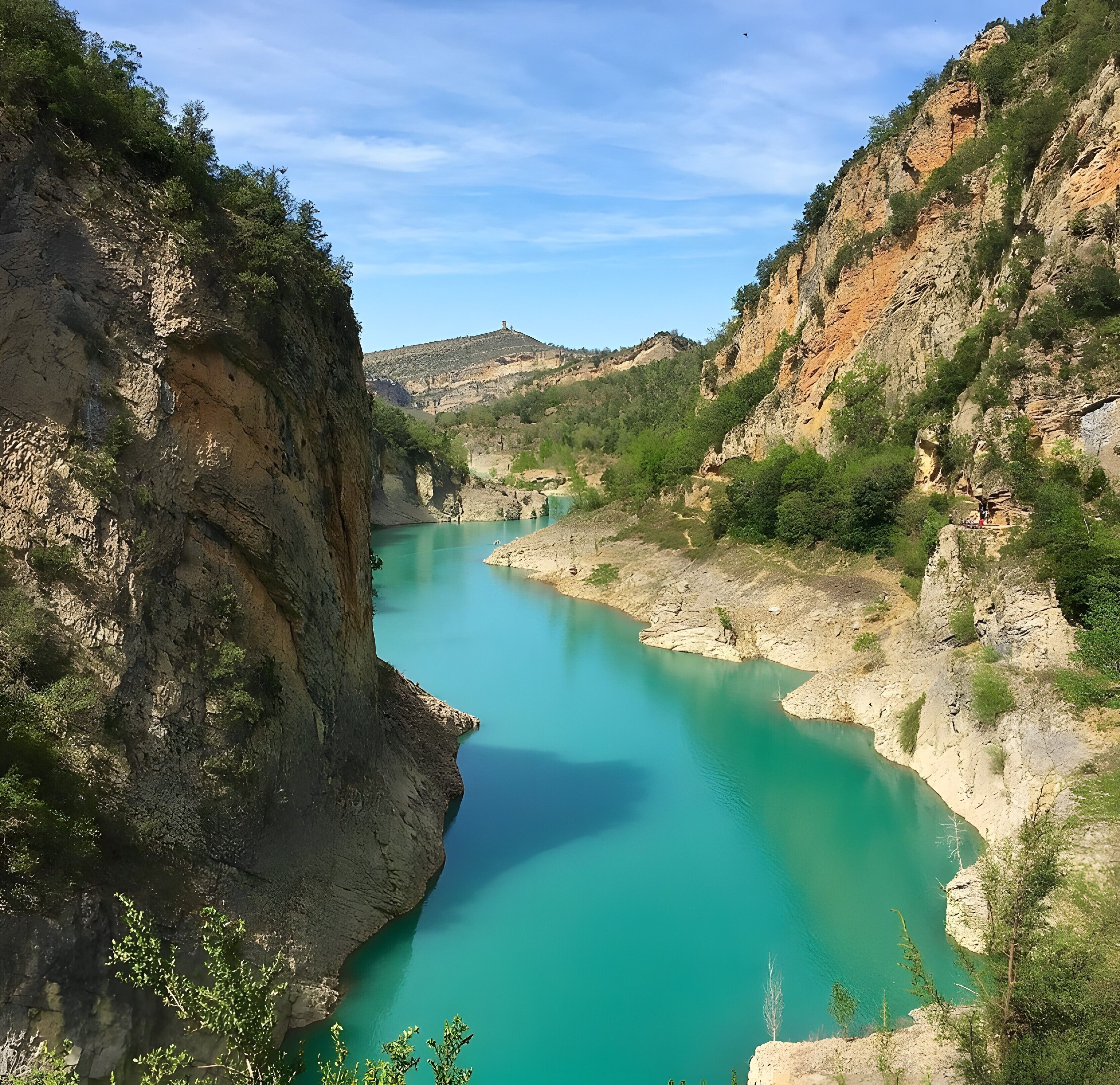 Un canyon traversé par une rivière, avec des falaises rocheuses et une végétation clairsemée.