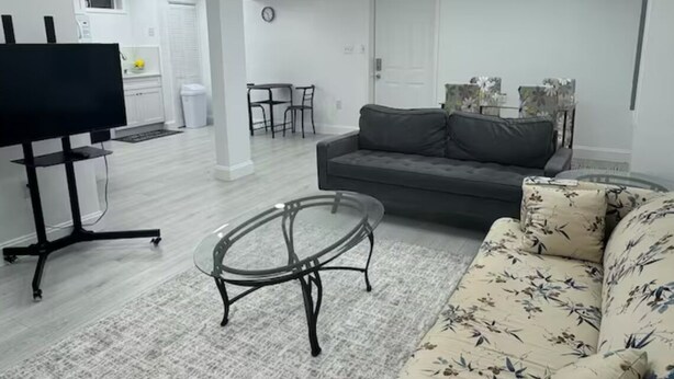 Un salon moderne avec un canapé, une table basse et un téléviseur posé sur un meuble.