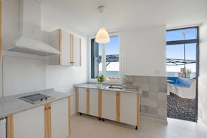 Una cucina moderna con isola integrata, una finestra vista e una lampada a sospensione.