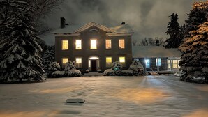 A large, snow-covered building with multiple windows and a central entrance.
