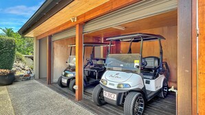 Un garaje con dos carros de golf estacionados adentro.