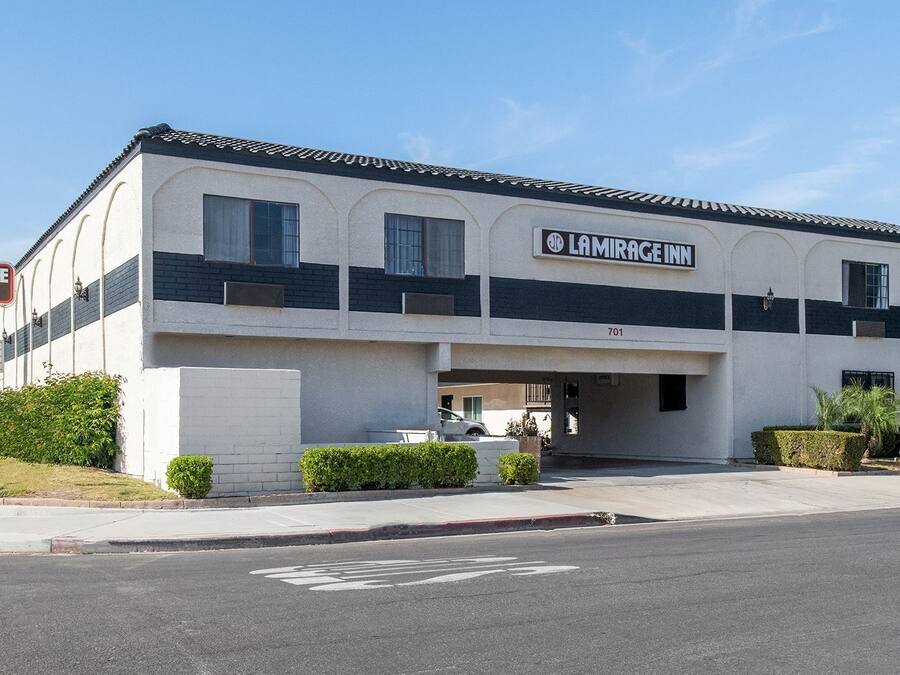 A two-story building with a sign for 'LAMIRAGE INN' and a parking sign indicating 'PARKING IN REAR'.