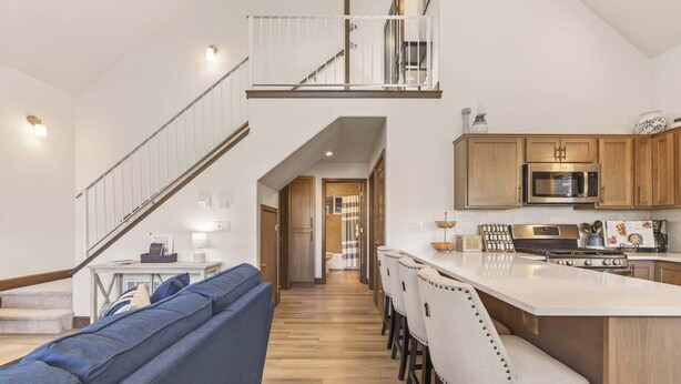 A modern kitchen with a central island, wooden cabinets, and a stainless steel microwave. - Dog Friendly Bungalow in the heart of Dover Bay (Dover)