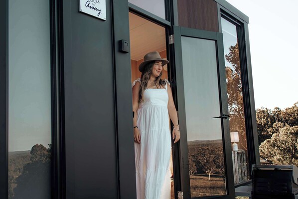 A person standing at a doorway with a sign that reads 'Away.'