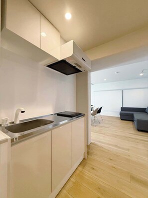 Una cocina moderna con un lavaplatos empotrado, una campana extractora negra y una encimera gris.