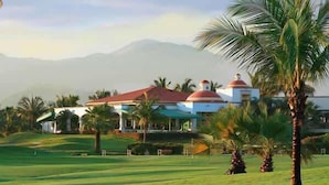 A golf course with a clubhouse featuring domed roofs and palm trees. - El Tigre: Luxury, Pool, Golf view and near Beaches! (Nuevo Vallarta)