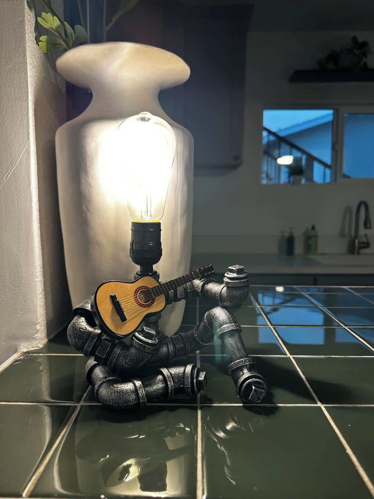 Ein Badezimmer mit einer großen weißen Vase, einer Gitarre und einem Waschbecken.