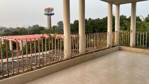 A covered outdoor area with a tiled floor and a metal fence. - KOSHA RESORT (Meerut)