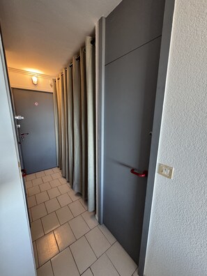Stylish hallway leading to a room with a door and natural light.