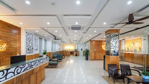 A modern hotel lobby with a reception desk, seating area, and decorative elements. - Coral Cove Hotel (Da Nang)