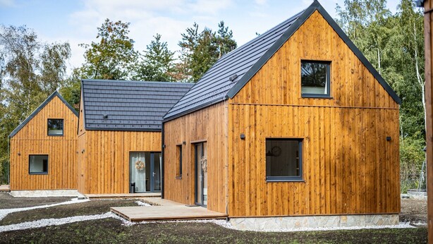 A modern wooden cabin with a sloped roof, a small porch, and a stone foundation. - Villa in Cervene Janovice Near Kutna Hora Castle (Červené Janovice)