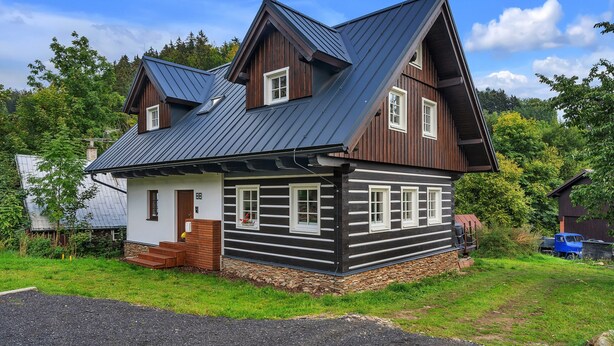 A log cabin with a steep gabled roof, stone foundation, and a small porch with steps leading to the door. - Villa in Austria Near Ski Slopes & Sauna (Rokytnice nad Jizerou)