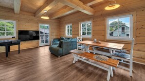 A wooden cabin interior with a sofa, a table, and a foosball table. - Villa in Austria Near Ski Slopes & Sauna (Rokytnice nad Jizerou)