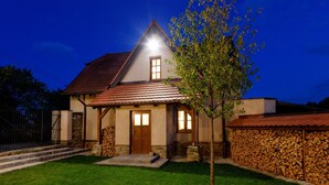 A house with a sloped roof, a wooden door, and a small tree in the front yard. - Villa in Varvazov With Garden and Barbecue (Varvažov)