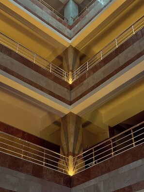 En flerplans atriumgård med et åbent centralt område og gelændere på hver etage.