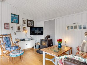 Un salon chaleureux avec une cheminée, des meubles en bois et des œuvres d’art accrochées aux murs.
