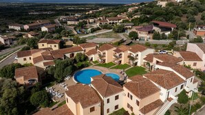 A residential area with multiple houses, a swimming pool, and a view of the sea. - Ancora Sardinia Seaside Apartment (Badesi)