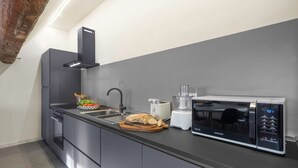 Une cuisine moderne équipée d’un four encastré, d’un four à micro-ondes et d’un robot culinaire.