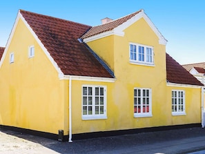 A yellow building with a red roof, white window frames, and shutters. - 5 Star Holiday Home in Lokken (Lokken)