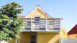 Un edifici de dues plantes amb un balcó, una porta i una finestra.
