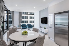 Enjoy a city view from the comfort of this living room, featuring a dining table, comfortable seating, and a flat-screen TV.